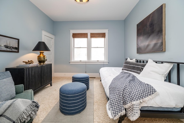 bedroom featuring light carpet and baseboards