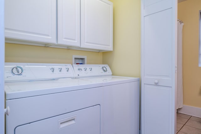 laundry room with light tile patterned floors, independent washer and dryer, cabinet space, and baseboards