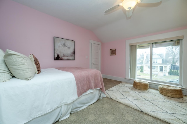 bedroom featuring lofted ceiling, baseboards, a ceiling fan, and light colored carpet