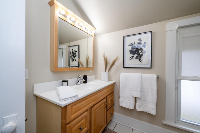 bathroom with lofted ceiling, tile patterned flooring, and vanity