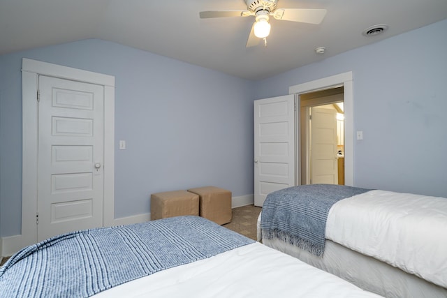 carpeted bedroom featuring lofted ceiling, visible vents, ceiling fan, and baseboards