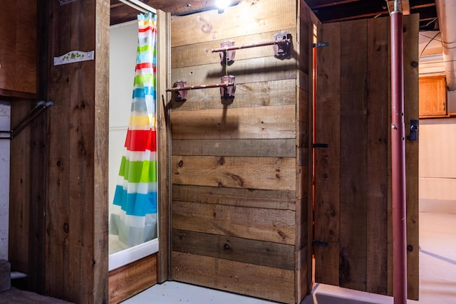 bathroom featuring wood walls