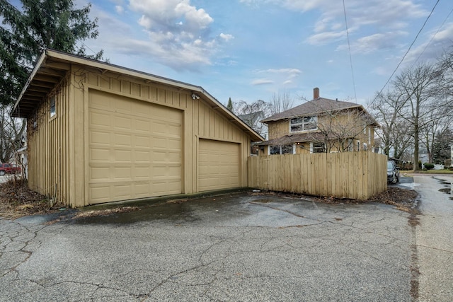 detached garage featuring fence