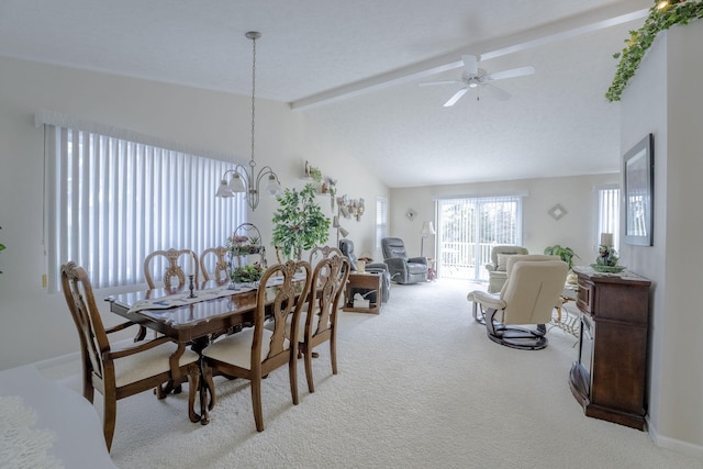 carpeted dining space featuring ceiling fan with notable chandelier and vaulted ceiling with beams