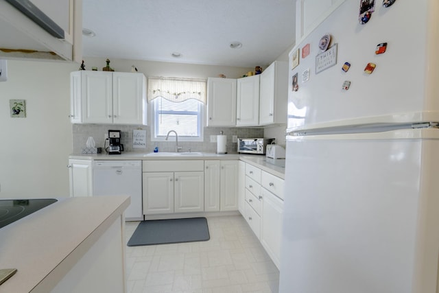 kitchen featuring white cabinetry, white appliances, sink, and backsplash