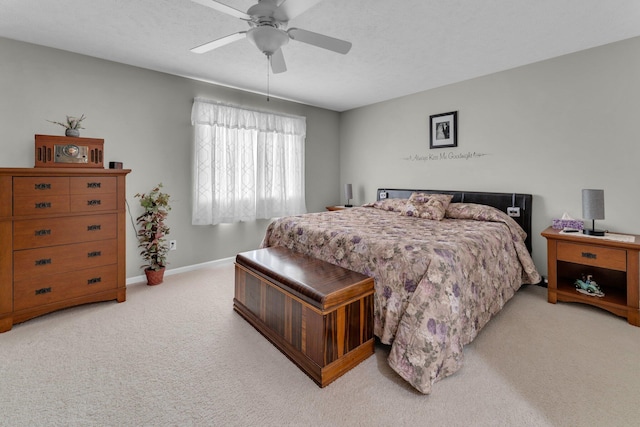 carpeted bedroom featuring a textured ceiling and ceiling fan