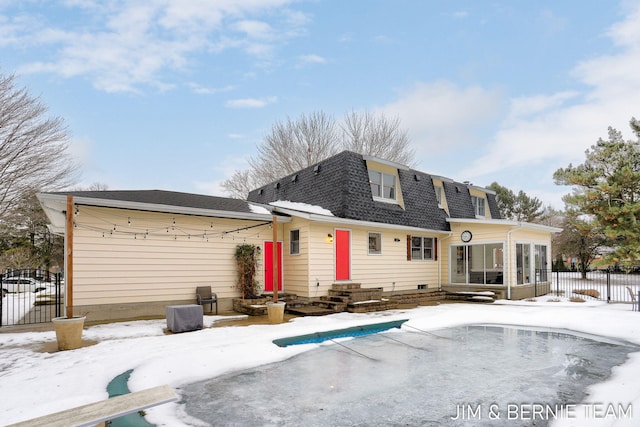 snow covered property featuring a sunroom