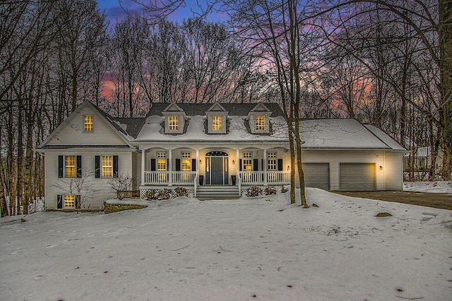 cape cod-style house with a garage and a porch