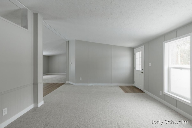 empty room with carpet floors and a textured ceiling