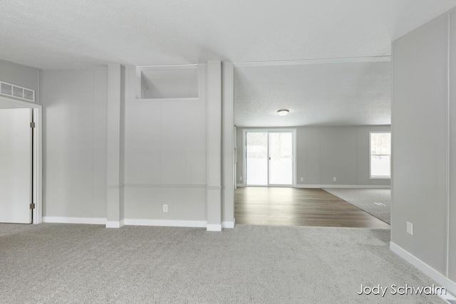 carpeted empty room featuring a textured ceiling