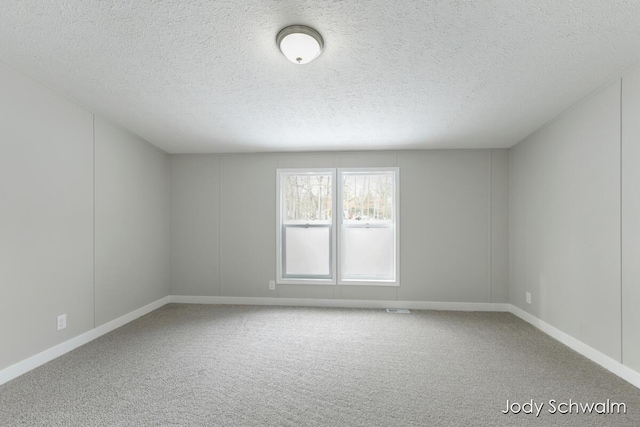 spare room with carpet flooring and a textured ceiling