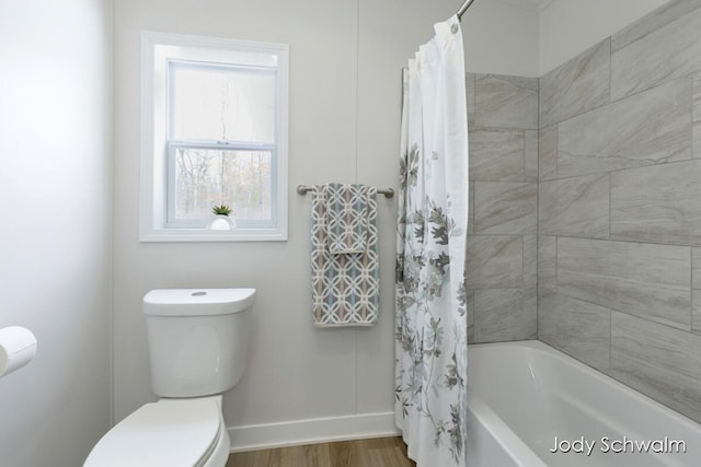 bathroom with hardwood / wood-style floors, toilet, and shower / bath combo with shower curtain