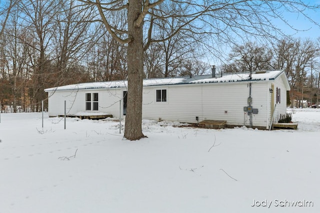 view of snow covered back of property