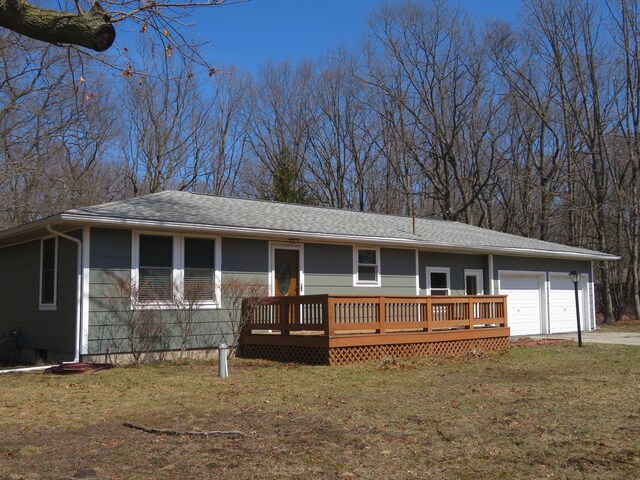 606 Wall St, Eastlake, MI 49626 - ranch-style house with a front lawn, a garage, a wooden deck, driveway, and roof with shingles