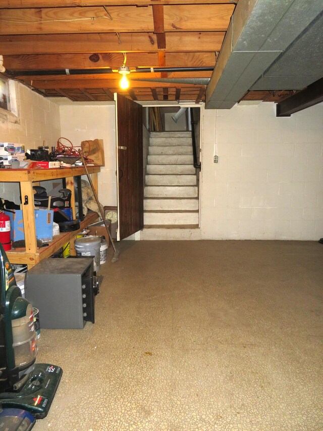 606 Wall St, Eastlake, MI 49626 - unfinished basement featuring stairway, concrete block wall, and a workshop area