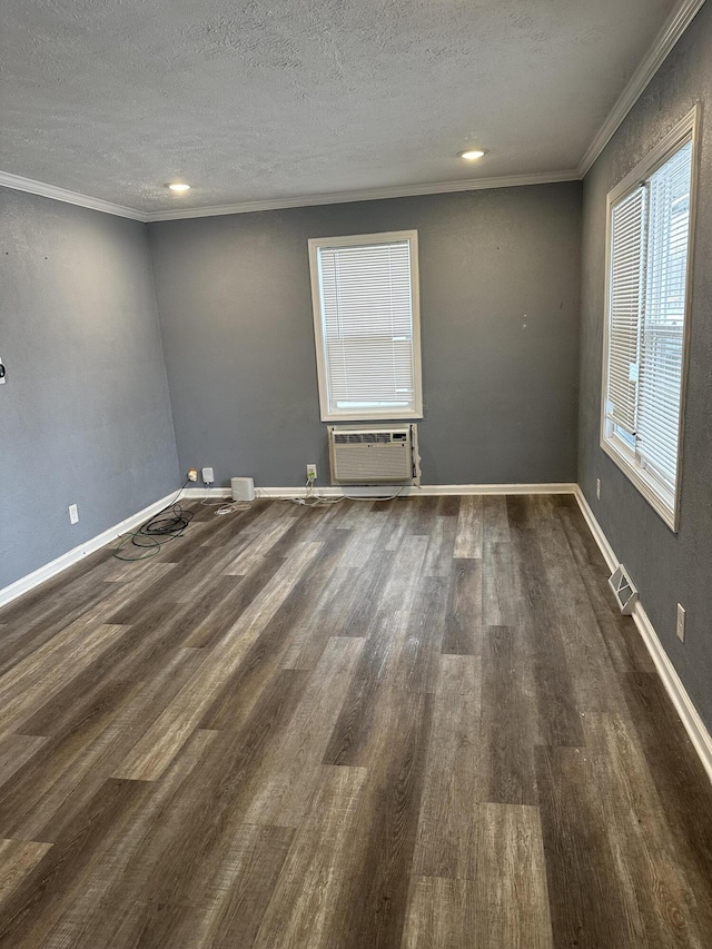 spare room featuring dark hardwood / wood-style flooring, crown molding, a textured ceiling, and a wall mounted AC