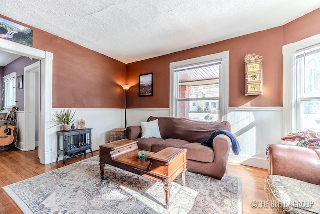 living room featuring a textured ceiling and light wood-type flooring