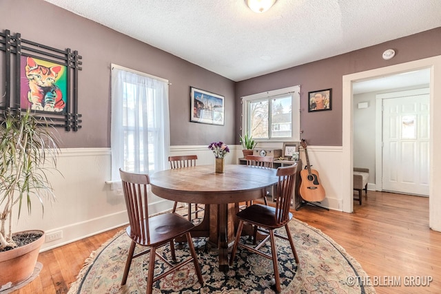 dining space featuring light hardwood / wood-style floors and a textured ceiling