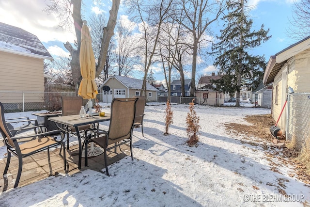 snow covered patio featuring a storage shed