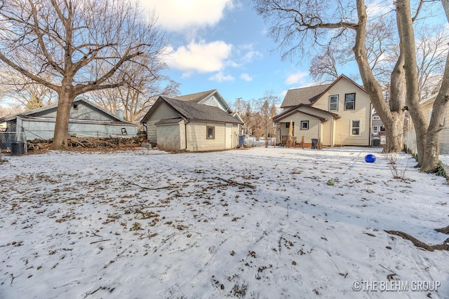 snow covered back of property with an outbuilding