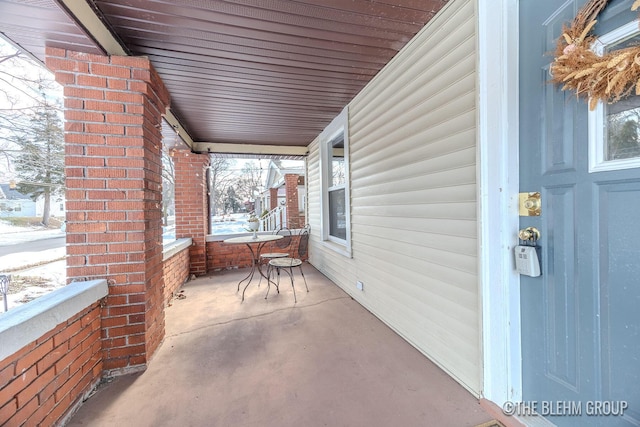 snow covered patio featuring a porch