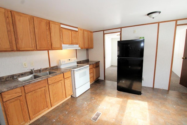 kitchen featuring black refrigerator, sink, and white range with electric stovetop