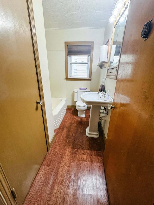 bathroom featuring hardwood / wood-style floors, sink, a tub, and toilet