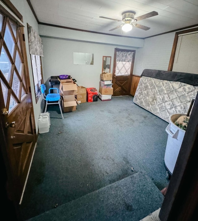 carpeted bedroom featuring ornamental molding and ceiling fan