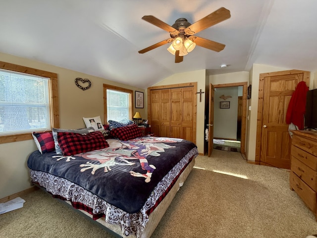 bedroom featuring vaulted ceiling, light colored carpet, ceiling fan, and a closet