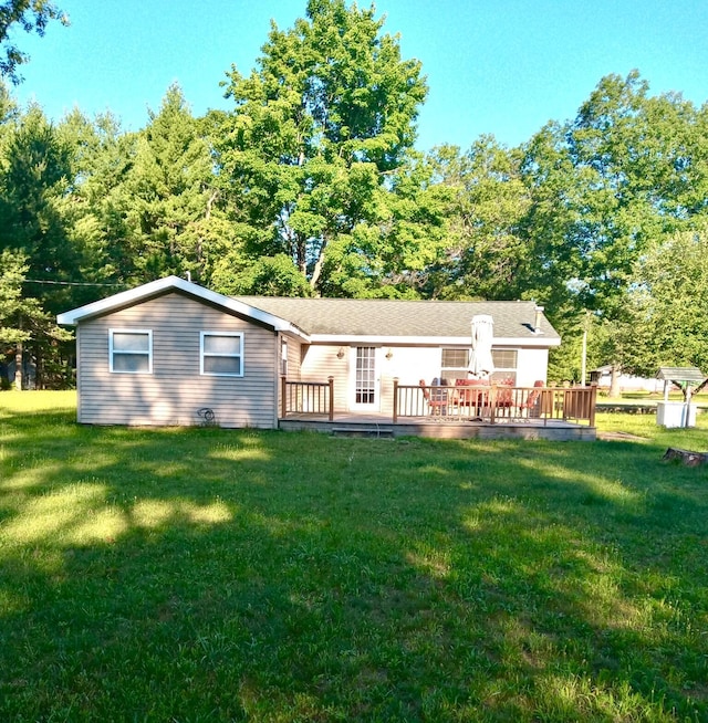 rear view of property with a deck and a lawn