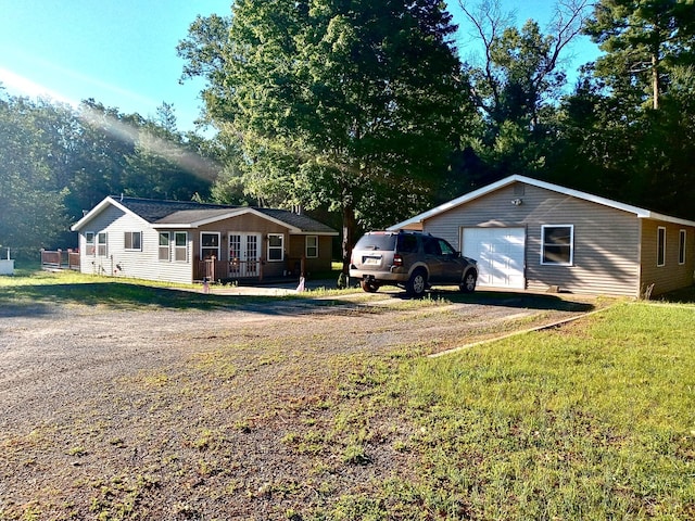 view of front facade featuring a garage, an outdoor structure, and a front yard