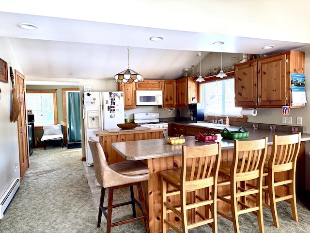 kitchen with pendant lighting, sink, white appliances, a baseboard radiator, and kitchen peninsula