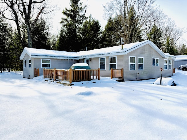 snow covered rear of property featuring a deck