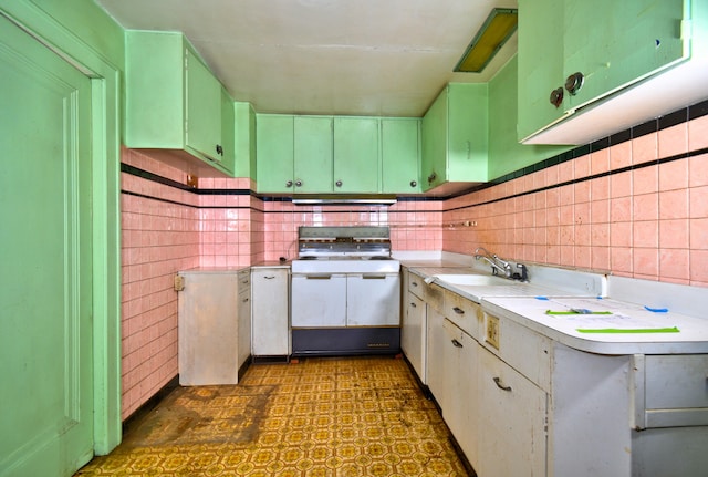 kitchen with sink, white range, white cabinets, and tile walls