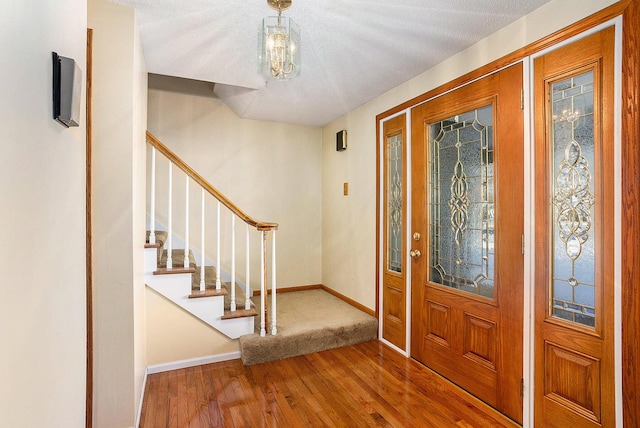 foyer entrance with hardwood / wood-style flooring and a chandelier