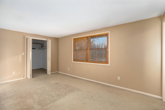 unfurnished bedroom with light colored carpet, a closet, and a textured ceiling