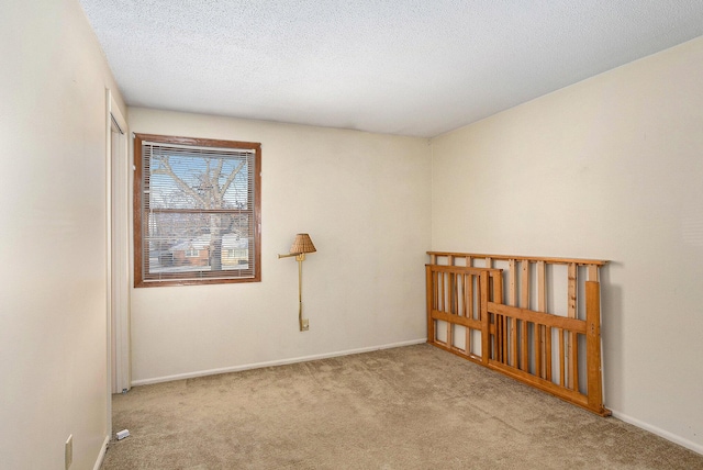 carpeted spare room with a textured ceiling