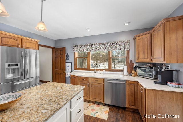 kitchen featuring sink, white cabinetry, decorative light fixtures, appliances with stainless steel finishes, and dark hardwood / wood-style flooring