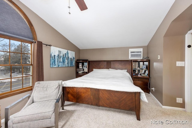 carpeted bedroom featuring ceiling fan, vaulted ceiling, and a wall unit AC