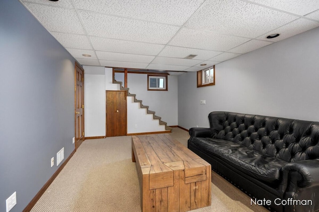 living room featuring carpet floors and a drop ceiling