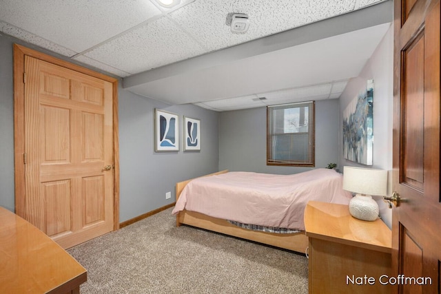 bedroom with carpet flooring and a drop ceiling