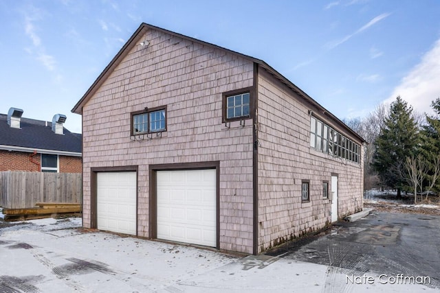 view of snow covered exterior with a garage