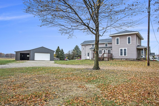 view of front facade with a garage, an outdoor structure, and a front lawn