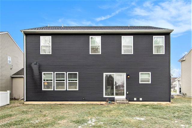 rear view of property featuring a lawn