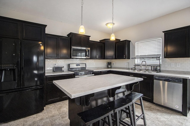 kitchen featuring sink, decorative backsplash, hanging light fixtures, a center island, and stainless steel appliances