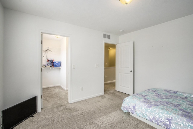 bedroom with a spacious closet and carpet floors