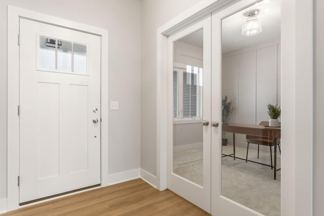 foyer featuring light wood-type flooring and french doors