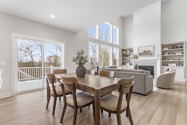 dining area featuring plenty of natural light, a high ceiling, and light wood-type flooring