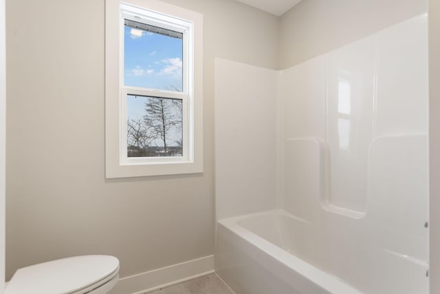 bathroom with tub / shower combination and toilet