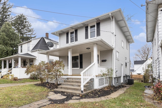 view of front of property featuring a front yard, covered porch, and cooling unit